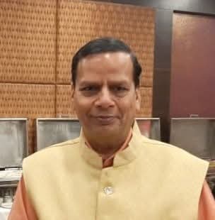 Veteran author Rajendra Mohan Sharma holding his latest book Nele Sapne Novel.